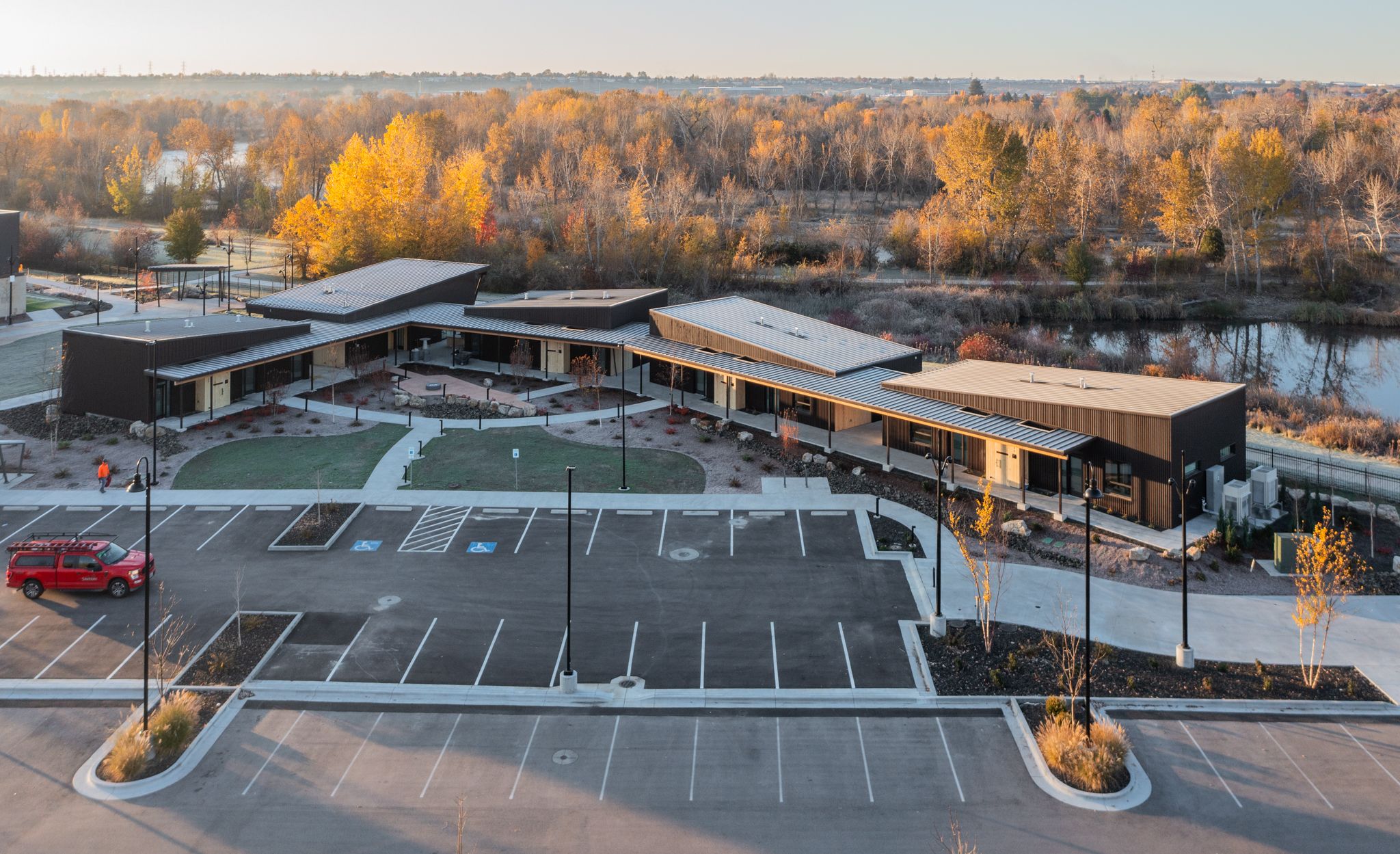An evening time exterior view of the Idaho Outdoor Fieldhouse campus with housing units and landscaping.