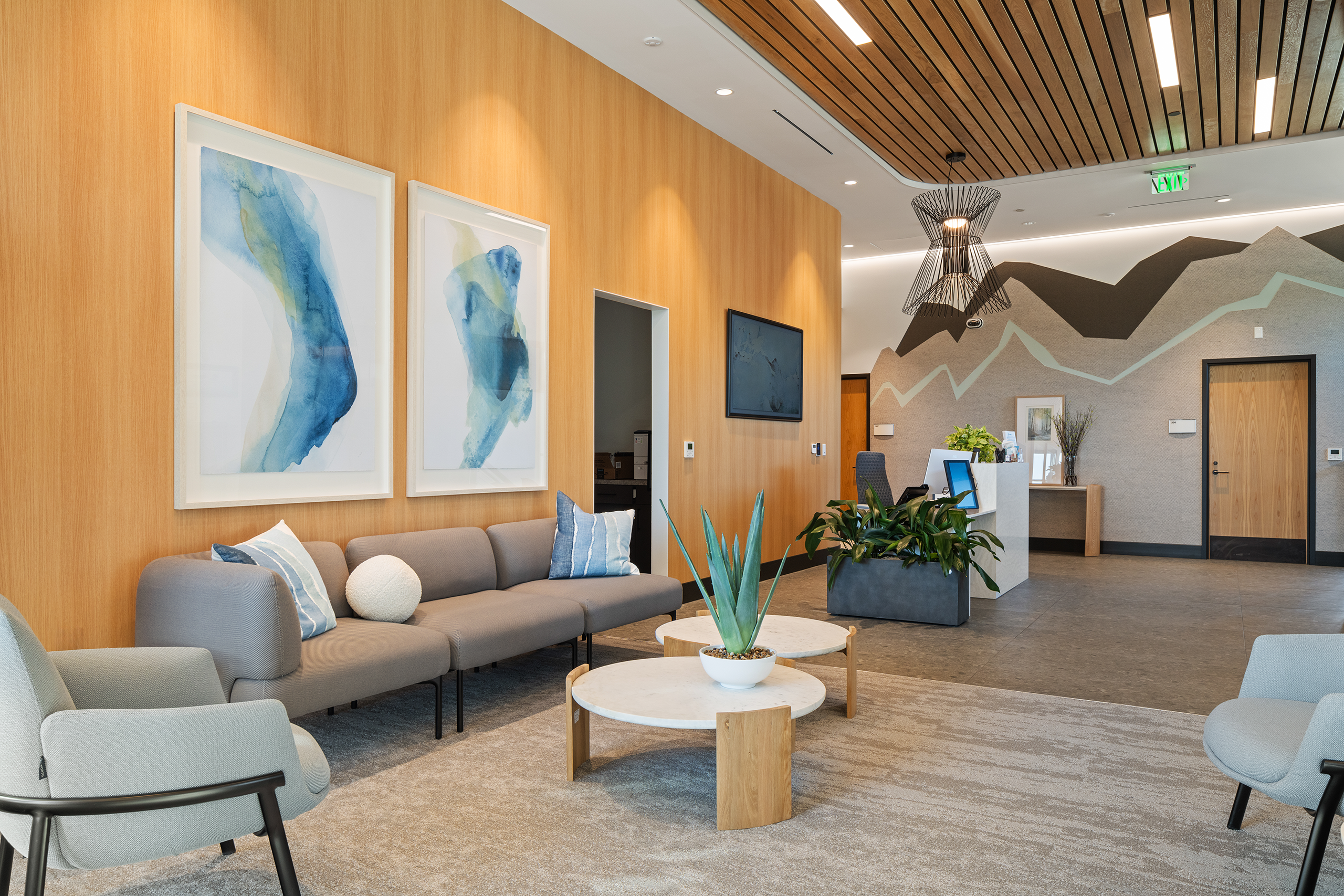Upstairs lobby at Summit Hyperbarics & Wellness with modern decor, seating area, abstract art, and a reception desk.